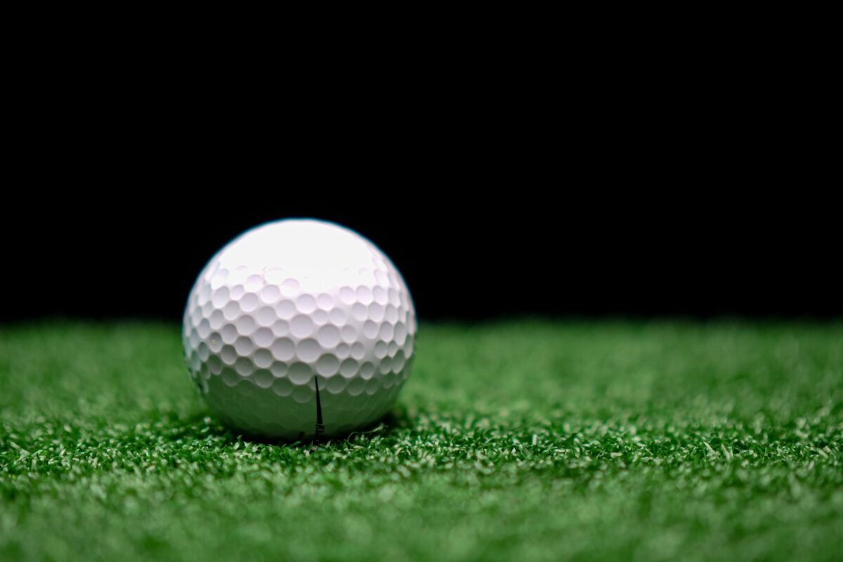 A golf ball photographed close up against a dark background