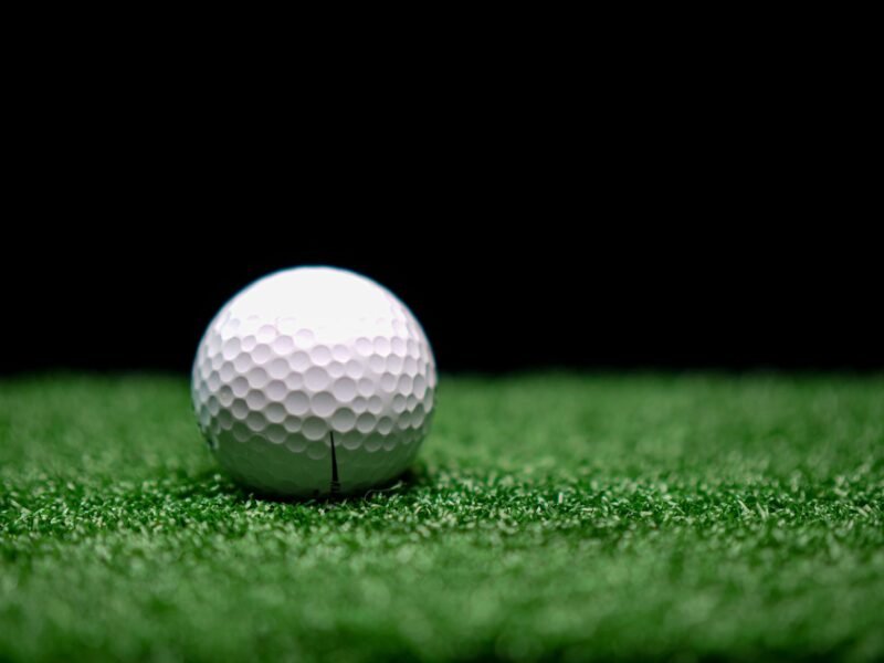 A golf ball photographed close up against a dark background