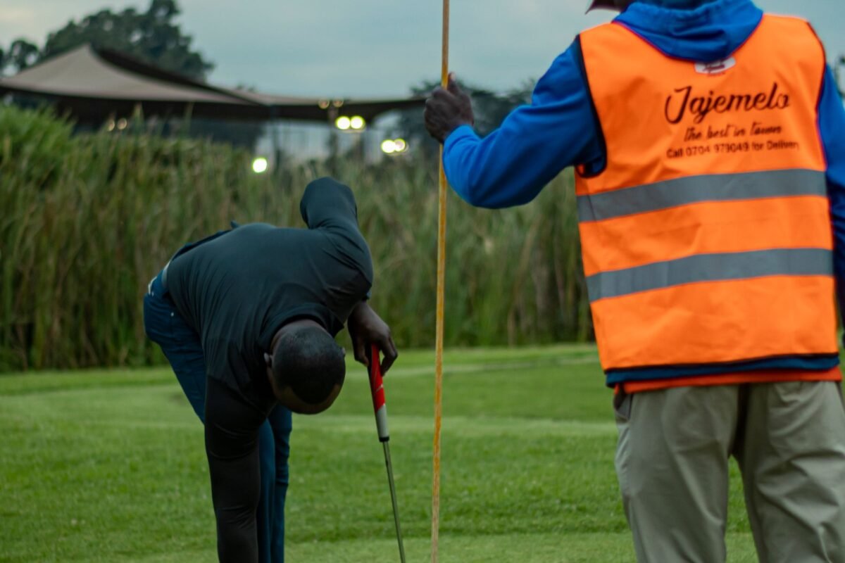 A caddy handing a club to a player on a golf course