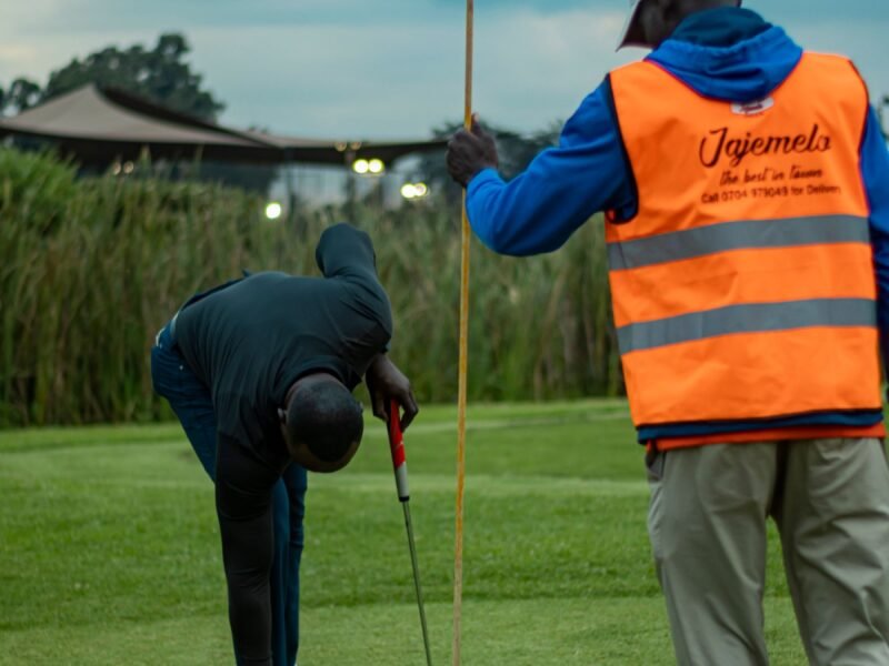 A caddy handing a club to a player on a golf course