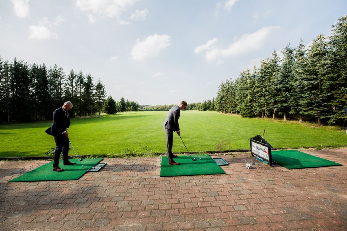 Two men in business dress playing a round of golf together