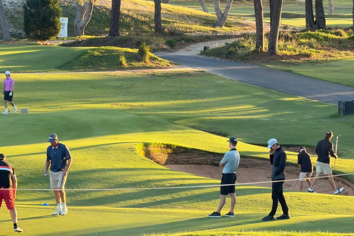 Golfers playing a hole on a sunny afternoon
