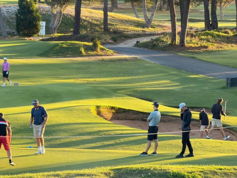 Golfers playing a hole on a sunny afternoon