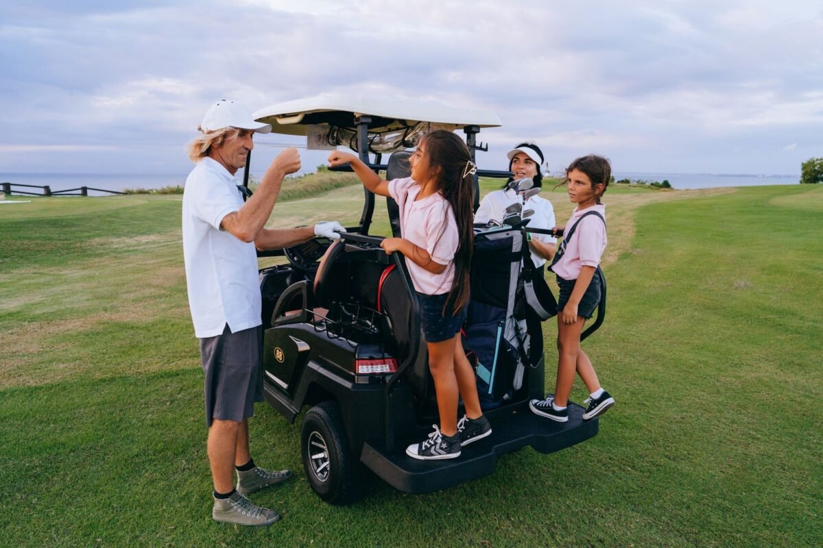 An adult and a child bumping fists on a golf course