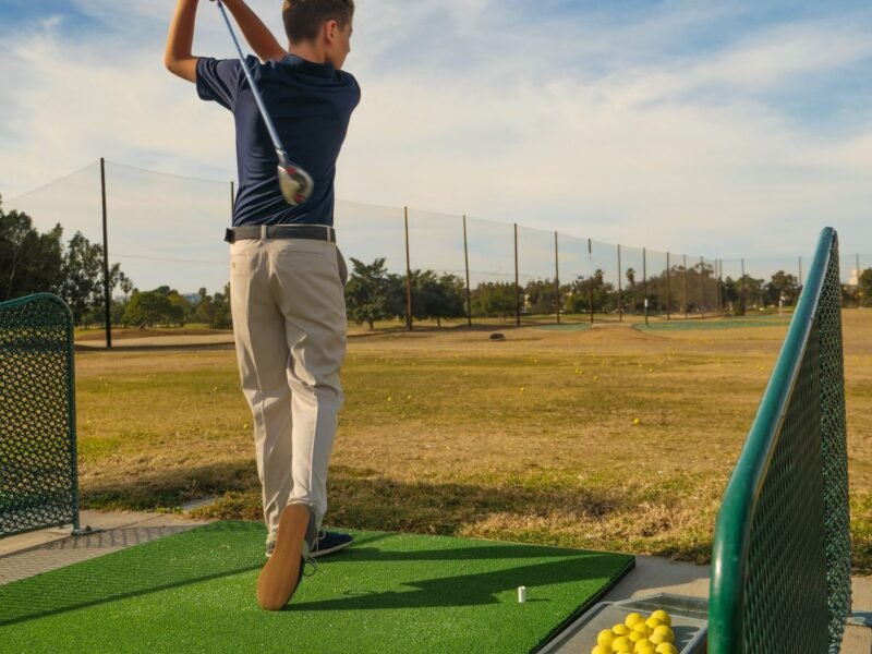 A young player at the finish position of a golf swing
