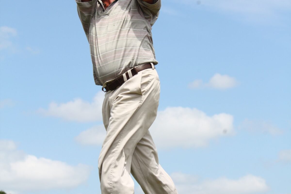 A player walking the fairway in a grey polo shirt
