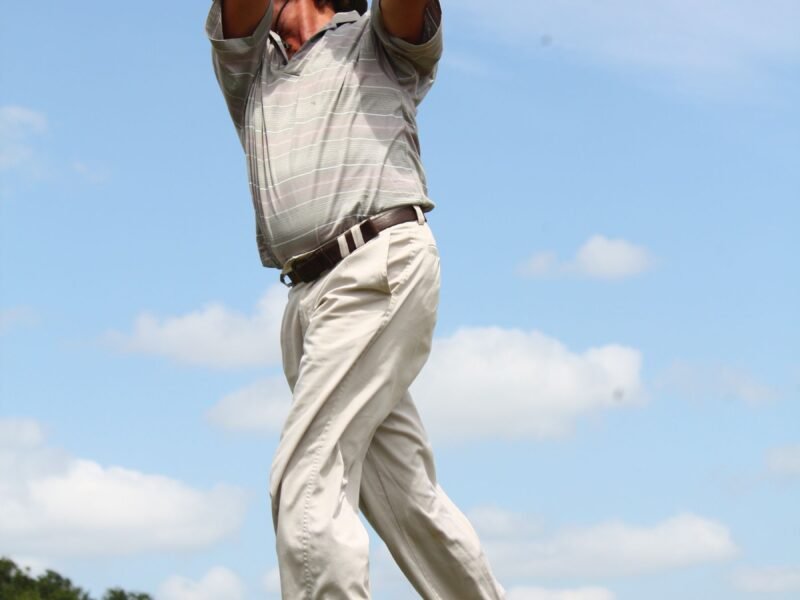 A player walking the fairway in a grey polo shirt