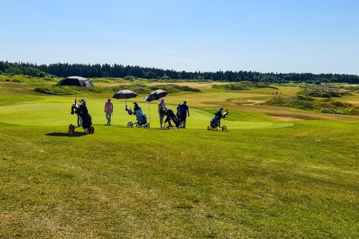 Players out on the grass under umbrellas