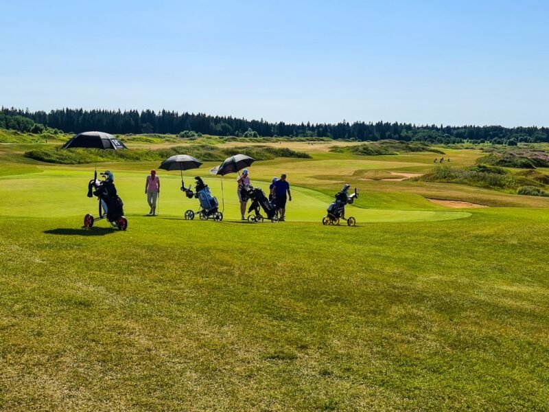 Players out on the grass under umbrellas
