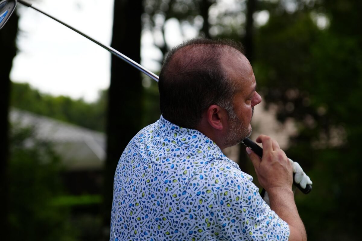 A player standing with a club on the course