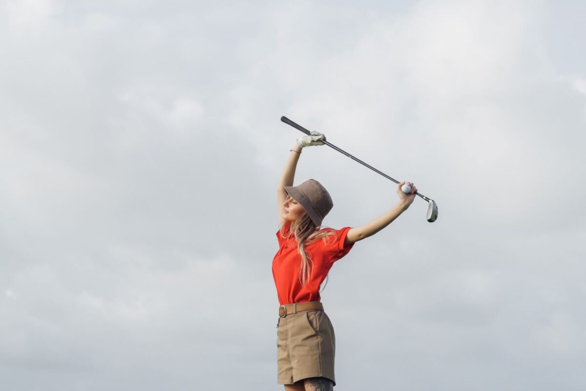 A woman holding a golf club on the course