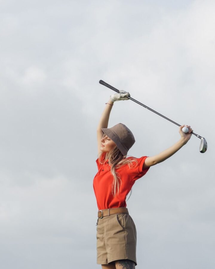 A woman holding a golf club on the course