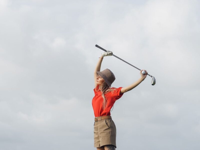 A woman holding a golf club on the course